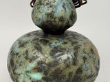 a green and black gourd sitting on top of a white table