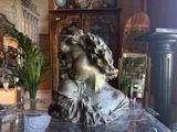 a statue of a woman sitting on a glass table