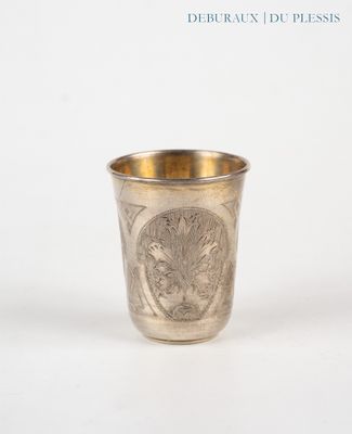 a silver cup with a design on it on a white surface