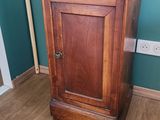 une petite armoire en bois dans un coin de la pièce