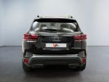 the rear end of a black suv parked in a white room