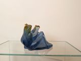 a glass table with a blue vase on top of it
