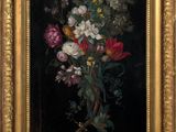 painting of a bouquet of flowers in a gold frame on a black background