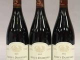 trois bouteilles de vin rouge sont alignées sur une table