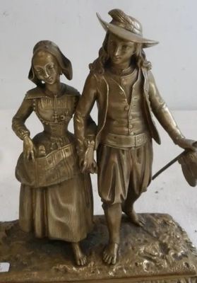 figurine en bronze représentant un homme et une femme tenant un balai