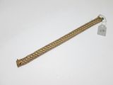 a close up of a gold chain bracelet on a white surface