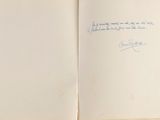 an open book with a handwritten quote on it sitting on top of a table