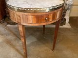 une table au plateau en marbre devant une cheminée