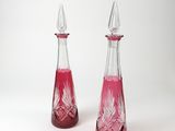 deux bouteilles en verre contenant un liquide rouge, posées sur une surface blanche
