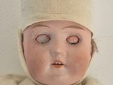 a close up of a doll with a hat on