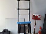 a ladder that is leaning against a wall next to a bag