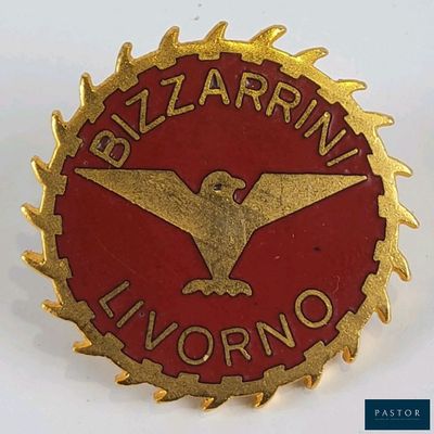 une image représentant un pin's rouge et doré orné d'un aigle