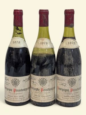 trois bouteilles de vin rouge sont posées les unes à côté des autres sur une surface blanche