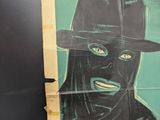 a poster of a man with a hat on a wall
