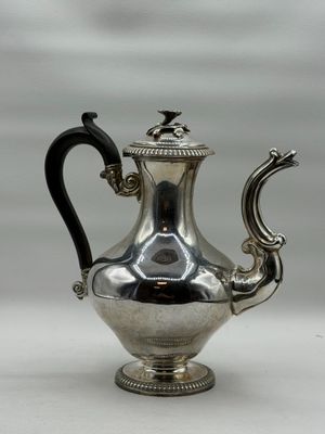 silver plated tea pot with black handle and handle