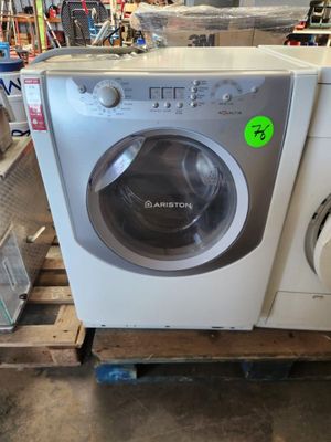 une machine à laver posée sur une palette dans un magasin