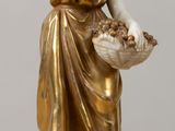 une figurine représentant une femme tenant un panier de fleurs