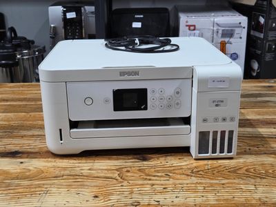 a white printer sitting on top of a wooden table