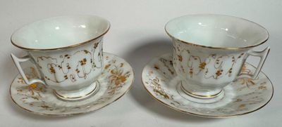 two cups and saucers sitting on top of a white table