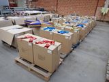 Plusieurs cartons sont empilés sur des palettes dans une zone d'entrepôt