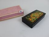 a small box with a painting on it next to a small box with a painting on it