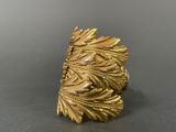 a close up of a gold ring with leaves on it