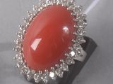 une image d'une bague avec une pierre rouge entourée de diamants blancs