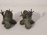 two figurines of a man with antlers on them