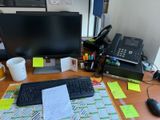 un bureau sur lequel se trouvent un ordinateur, un clavier, une souris et des papiers