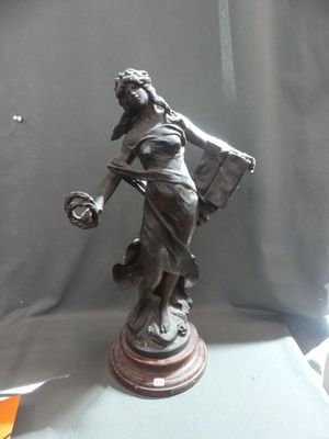 a statue of a woman holding a basket and a bag