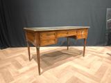 a wooden desk with a marble top on a parquet floor