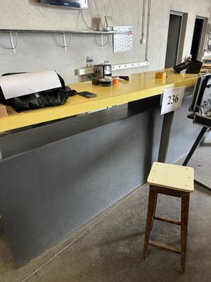 un comptoir jaune avec un tabouret devant