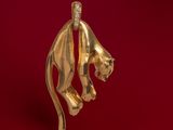 a close up of a gold lion head on a red background