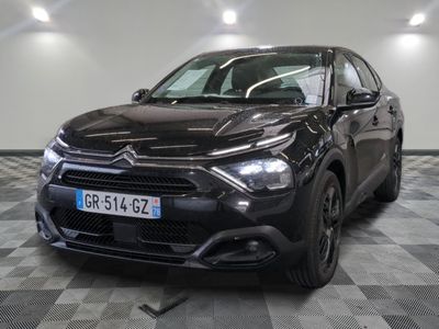 the black car is parked on a checkered floor in the garage