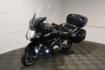 a black motorcycle parked in a room with a checkered floor