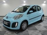 la photo d'une petite voiture bleue garée sur un sol en damier