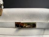 a white purse that has a lock on it