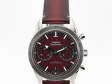 un gros plan d'une montre avec un bracelet rouge sur un fond blanc