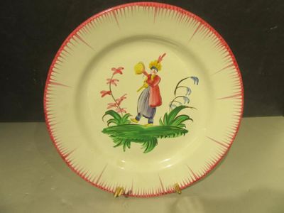 une assiette sur laquelle est représentée une petite fille et un oiseau