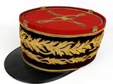 un chapeau rouge et noir orné d'un motif doré