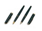 three pens and a ballpoint pen sitting next to each other