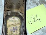 un flacon de parfum posé sur une table, avec un petit mot dessus