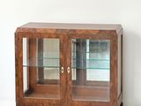 une armoire en bois avec des portes vitrées dans une pièce blanche