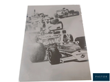 an old photo of a race car going down the track