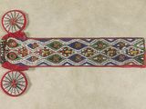 un gros plan d'une ceinture ornée de perles sur un fond blanc