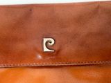 brown leather purse with a small metal letter on the front