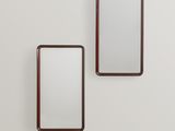 deux miroirs rectangulaires fixés au mur d'une pièce blanche