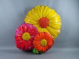 Des fleurs aux couleurs vives sont disposées dans un vase posé sur une surface grise
