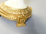 une lampe de table blanche et dorée posée sur une table blanche