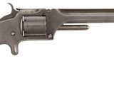 un vieux revolver avec un manche en bois sur fond blanc